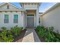 Close-up of a modern home's inviting double door entrance and landscaped walkway at 17324 Sandpearl Rd, Venice, FL 34293