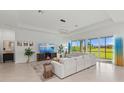 Large living room featuring stylish decor, tile flooring, and lots of natural light at 17324 Sandpearl Rd, Venice, FL 34293