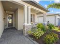 Charming front porch sitting area with stone columns and manicured garden at 2000 Gardenia Ave, Port Charlotte, FL 33953