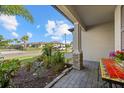 Charming front porch sitting area with stone columns and manicured garden at 2000 Gardenia Ave, Port Charlotte, FL 33953
