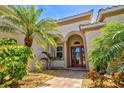 Elegant front entrance with a beautiful stone walkway, mature landscaping and a glass front door at 20126 Elegante Ct, Venice, FL 34293