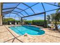 Screened-in pool with beautiful water features and lush landscaping provides privacy and enjoyment at 20126 Elegante Ct, Venice, FL 34293