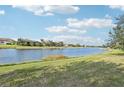 Expansive lake view showcasing the neighborhood, clear blue skies and grassy shoreline in a park-like setting at 20188 Tesoro Dr, Venice, FL 34293