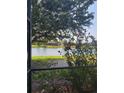 A serene lake view is featured from the screened lanai, with lush trees and plants in the foreground at 20188 Tesoro Dr, Venice, FL 34293