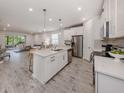 Bright, open kitchen with white cabinets, stainless steel appliances, and a large center island at 20285 Symphony Pl, Venice, FL 34293