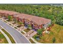Beautiful aerial view of townhomes with brick paved driveways, tropical landscaping and green spaces at 20290 Lagente Cir, Venice, FL 34293