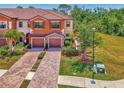 Inviting townhome featuring a tiled roof, two-car garage, and landscaped front yard at 20290 Lagente Cir, Venice, FL 34293