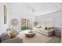 Bright living room features neutral tones, comfortable seating, and sliding door access to a screened lanai at 24477 Lakeside Mnr, Punta Gorda, FL 33980