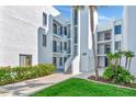 Modern white condo building with balconies, lush landscaping, and well-maintained grounds at 2955 N Beach Rd # A422, Englewood, FL 34223