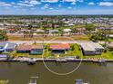 Drone shot of a home on a canal with a private boat dock, surrounded by lush greenery, and clear waterways at 322 Oakwood Cir, Englewood, FL 34223