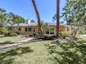 Beautiful one-story home featuring mature trees, a brick pathway, and a well-manicured lawn at 337 Harbor S Dr, Venice, FL 34285