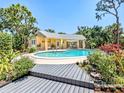 Beautiful pool area with a covered patio for lounging, surrounded by lush tropical landscaping at 337 Harbor S Dr, Venice, FL 34285