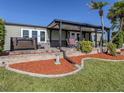 Backyard featuring a relaxing hot tub and covered patio area with plenty of seating and lush landscaping at 379 Harbor Isles Dr, North Port, FL 34287