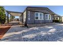 Inviting exterior with charming gray siding, a covered porch, and well-kept landscaping and walkway at 379 Harbor Isles Dr, North Port, FL 34287