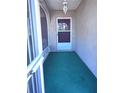 A welcoming front porch area with carpeting and a front door and a view of the outdoors at 407 Bahama Rd, Venice, FL 34293