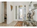 Elegant foyer featuring tile flooring, decorative glass door, and stylish decor at 5585 Semolino St, Nokomis, FL 34275