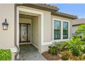 Close-up of the front entrance, highlighting the decorative glass door and manicured landscaping at 5585 Semolino St, Nokomis, FL 34275