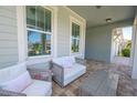 Covered front porch with a comfortable seating area and views of the neighborhood at 5632 Long Shore Loop, Sarasota, FL 34238