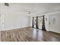 Bright living room with new hardwood flooring, ceiling fan, white walls, and abundant natural light at 5755 Oxalis Rd, Venice, FL 34293