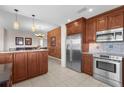 Gourmet kitchen featuring stainless steel appliances, granite countertops, and wooden cabinetry at 5800 Sabal Trace Dr # 101, North Port, FL 34287