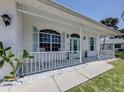 Inviting front porch with white railings, comfortable seating, and views of the surrounding neighborhood at 5931 Plover Rd, Venice, FL 34293