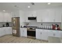 Updated kitchen featuring stainless steel appliances, granite countertops, and custom white cabinetry at 611 Paget Dr, Venice, FL 34293