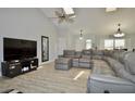 Spacious living room with vaulted ceilings, a large sectional sofa, and a modern entertainment center at 611 Paget Dr, Venice, FL 34293