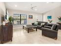 Inviting living room showcasing neutral paint, large windows, and sleek tile flooring at 6126 Spinnaker Blvd, Englewood, FL 34224