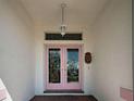Close-up of an elegant double front door with decorative glass panels and a vintage-style lantern at 617 Bonito Ave, Nokomis, FL 34275