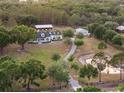 Aerial view showcasing the beautiful estate, pond and surrounding lush greenery, including barns at 6824 283Rd E St, Myakka City, FL 34251