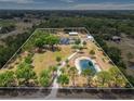 Expansive aerial view of the property, highlighting the home, pond, surrounding greenery and the defined boundary at 6824 283Rd E St, Myakka City, FL 34251