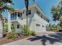 Two-story home featuring a two-car garage, palm trees, and lush landscaping at 770 Yale St, Englewood, FL 34223