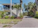Exterior view of a two-story house with a brick-paved driveway and screened-in porch at 770 Yale St, Englewood, FL 34223