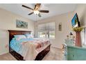Cozy bedroom features a ceiling fan, window with blinds, and a beach-themed decor with a dresser and artwork at 8997 Excelsior Loop, Venice, FL 34293