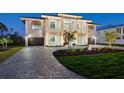 Magnificent two-story home displaying a lush green lawn, lovely landscaping, and a stone-paved driveway at 9810 Eagle Preserve Dr, Englewood, FL 34224