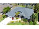 Aerial view of a beautiful home with lush landscaping, a driveway, and manicured lawn at 1124 W Hillsborough Blvd, North Port, FL 34288