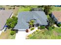 An aerial shot shows the home with its mature landscaping, driveway, and verdant lawn at 1124 W Hillsborough Blvd, North Port, FL 34288