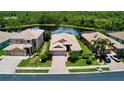 Beautiful aerial view of a home with well-manicured lawns, a brick driveway, and a serene pond view at 11437 Dancing River Dr, Venice, FL 34292