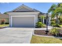 Attractive home featuring a neutral color scheme, attached two-car garage, and a well-maintained front yard with plants at 11455 Fort Lauderdale Pl, Venice, FL 34293