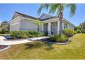 Beautiful home with lush landscaping, a winding walkway, covered porch, and an attached two-car garage at 11455 Fort Lauderdale Pl, Venice, FL 34293