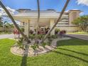 Beautifully landscaped entrance to a condo building with palm trees and colorful plants at 1150 Tarpon Center Dr # 3G 307, Venice, FL 34285