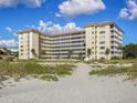 Beachfront condominium building with multiple floors and balconies, accessible from the sandy beach at 1150 Tarpon Center Dr # 3G 307, Venice, FL 34285
