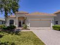 Charming single-story home featuring a tile roof, attached garage, and well-manicured lawn at 11610 Dancing River Dr, Venice, FL 34292
