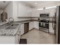 This is a kitchen with stainless steel appliances, white cabinets, and granite countertops at 12515 Felice Dr, Venice, FL 34293