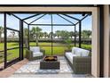 Screened in patio offering comfortable seating around a modern fire pit, perfect for outdoor entertaining at 12897 Oriago St, Venice, FL 34293