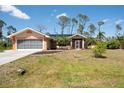 Single-story home with attached garage, lush lawn, and a walkway leading to the screened front entrance at 14124 Kewanee Ln, Port Charlotte, FL 33981