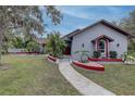 Stunning house exterior featuring unique red accents, lush plants, and a curved walkway at 181 S Auburn Rd, Venice, FL 34292