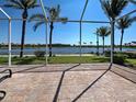 Screened-in patio with brick flooring and a beautiful view of the lake and palm trees at 19240 Isadora St, Venice, FL 34293