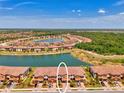 Aerial view of townhomes next to a large lake, surrounded by a lush landscape at 20390 Lagente Cir, Venice, FL 34293