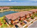Stunning aerial view of new townhomes near a tranquil lake and mature trees at 20390 Lagente Cir, Venice, FL 34293